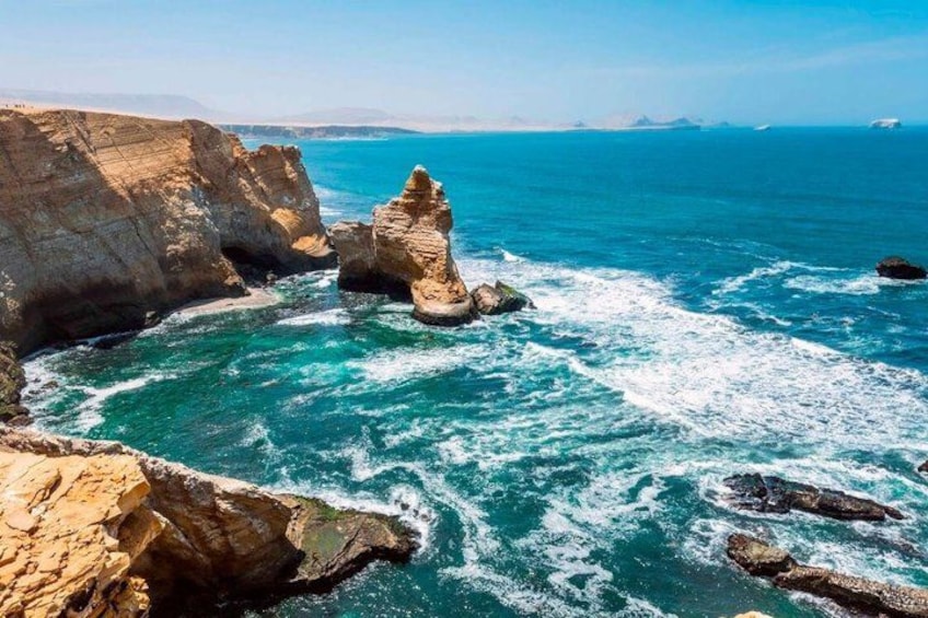 A coastal landscape with rocky formations and clear blue waters. 4