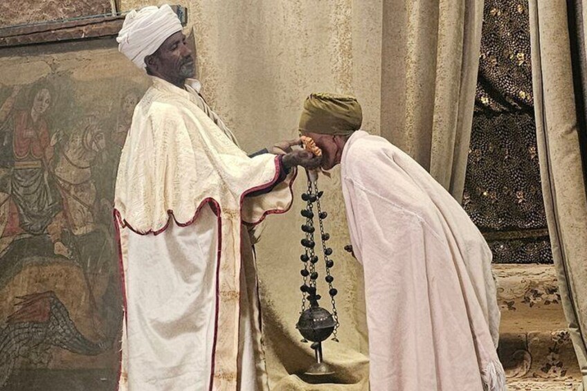 A person in traditional attire performing a ritual with a prayer bead. 5