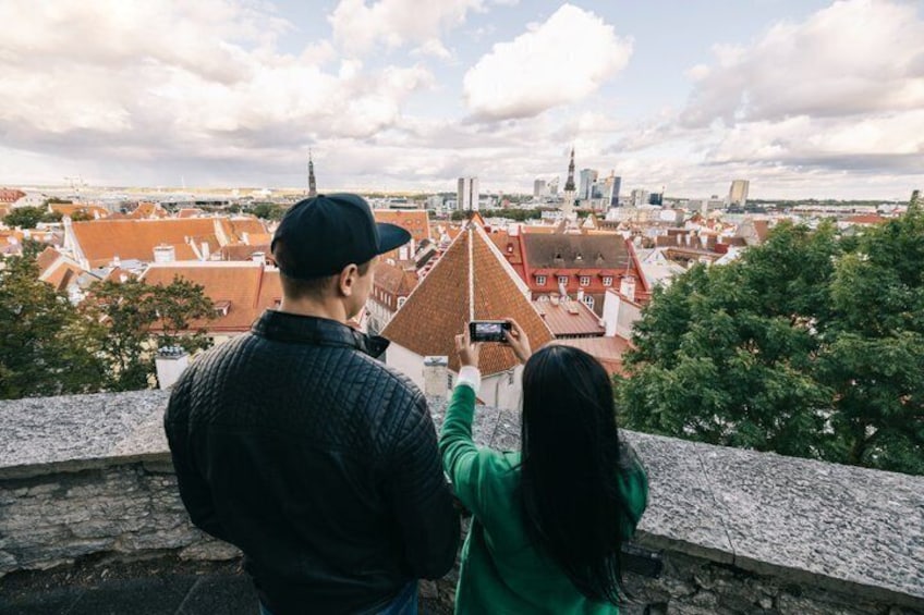 A couple overlooking a cityscape with a prominent tower. 3