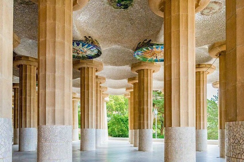 A series of columns with mosaic-tiled ceilings and a view of greenery outside. 4