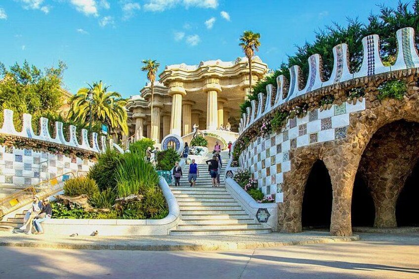 A staircase leading to a building with columns, surrounded by a decorative wall with arches. 3