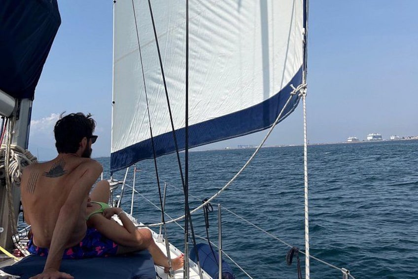 Un hombre en un velero con un tatuaje en la espalda, mirando al mar. 2