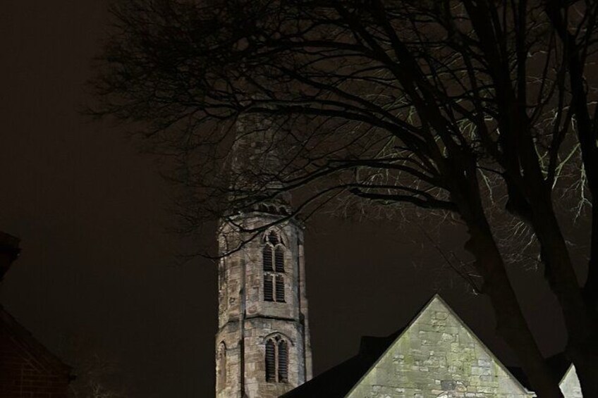 Une tour d’église de nuit, avec un arbre au premier plan. 3