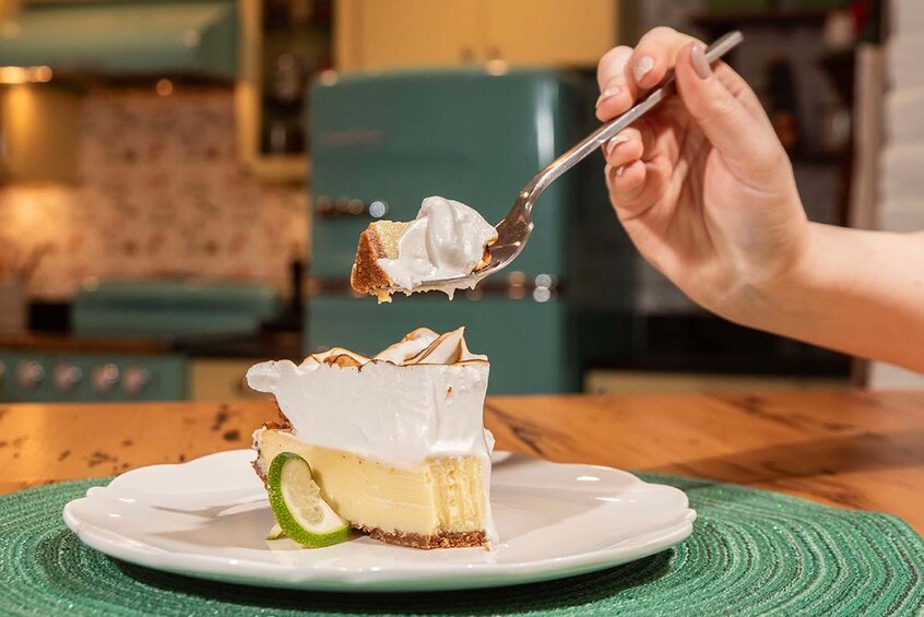 A slice of cheesecake with a lime wedge on a white plate. 3