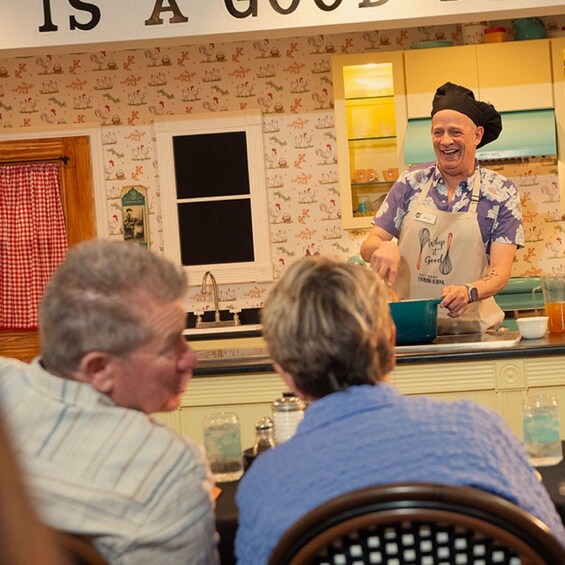 A person in a kitchen, wearing a chef's hat and apron, cooking at a counter. 4