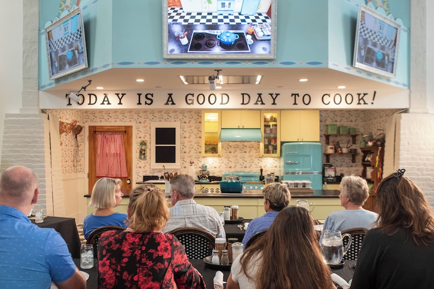 A restaurant with a sign that reads 'TODAY IS A GOOD DAY TO COOK!' and a kitchen visible through the window. 1