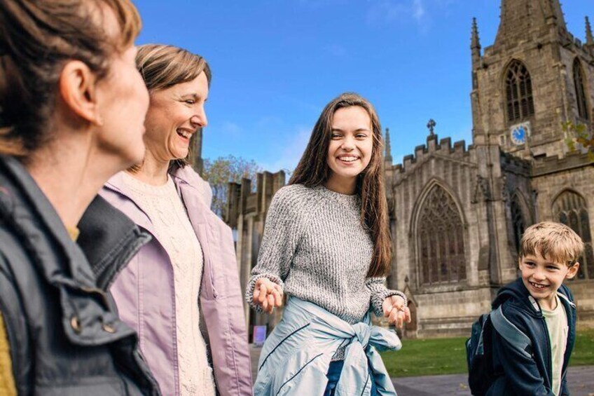 A group of people standing in front of a historic church with Gothic architecture. 5