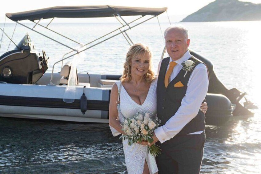 Un couple à bord d'un bateau, avec une chaîne de montagnes en arrière-plan. 4
