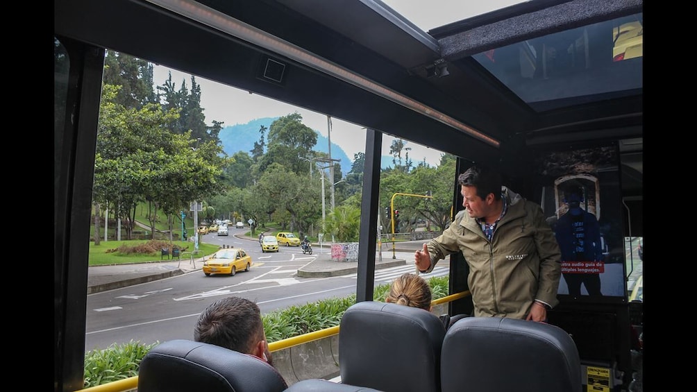 A bus interior with a view of a street, a yellow taxi, and a person standing by the window. 4