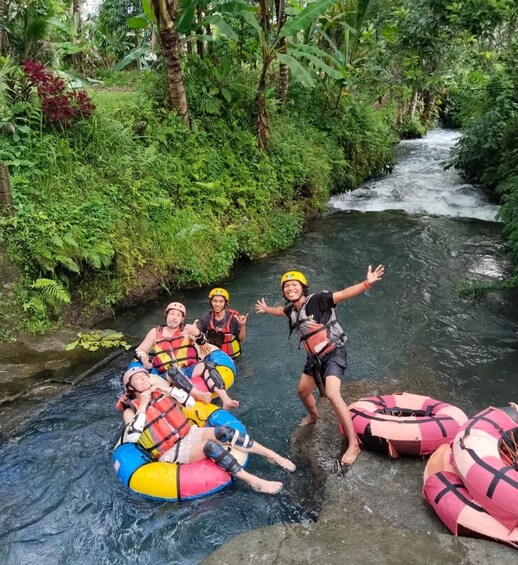 A group of people rafting on a river surrounded by lush greenery. 5