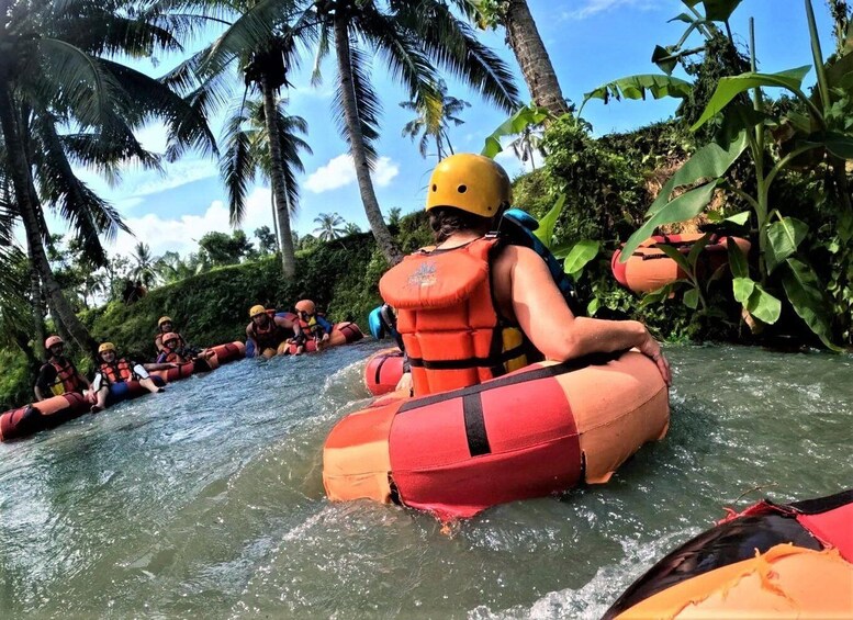 People rafting down a river surrounded by tropical vegetation. 1