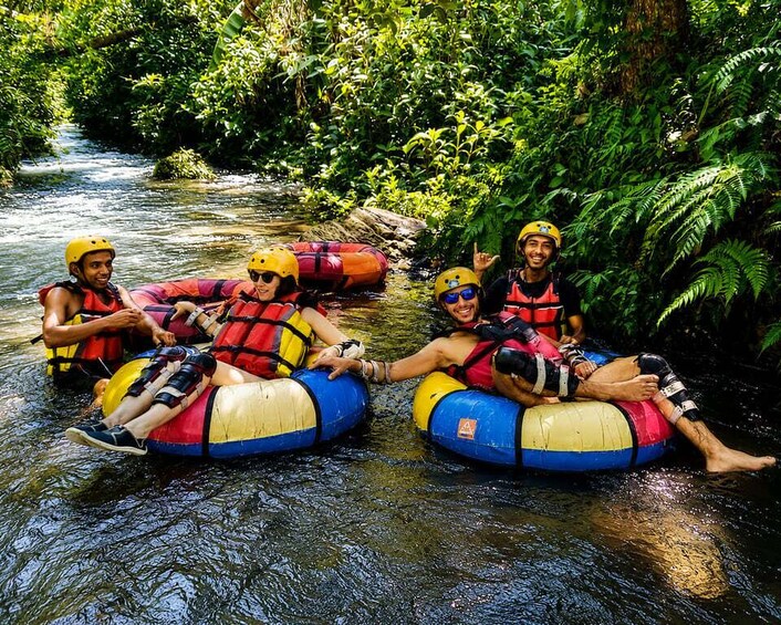 People rafting on a river surrounded by dense greenery. 4