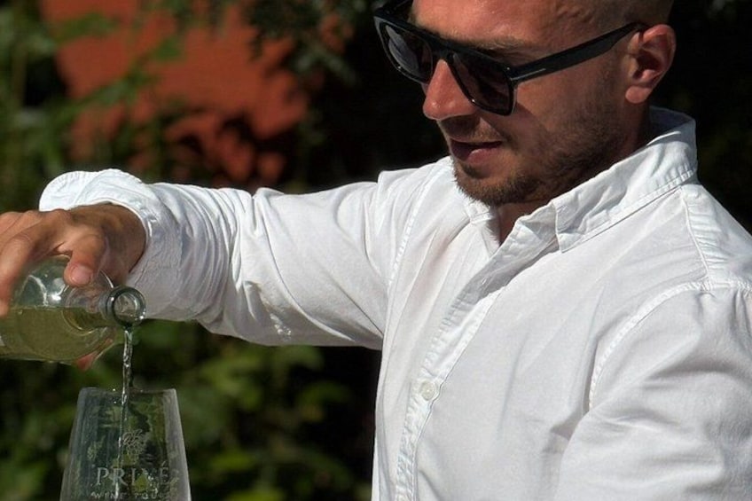 A person pouring a liquid from a bottle into a glass. 2