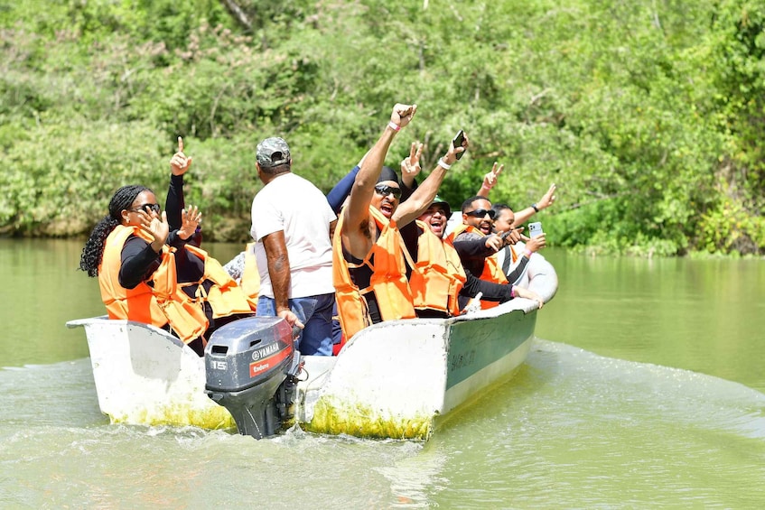 A group of people in a boat wearing life jackets, with one person steering. 1