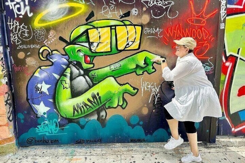 En person maler en graffiti-væg med et grønt slange-motiv og stjerner. 4