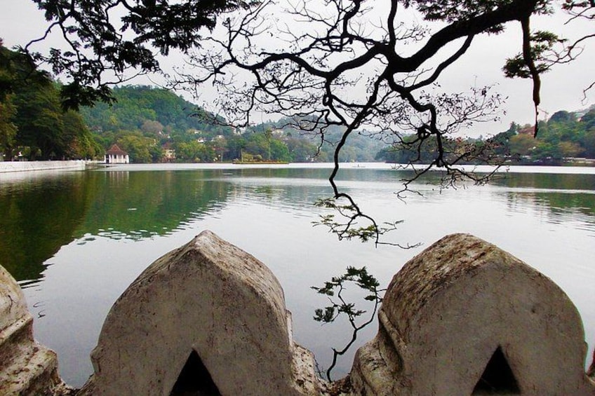 A calm lake with a stone bridge in the foreground and trees in the background. 5