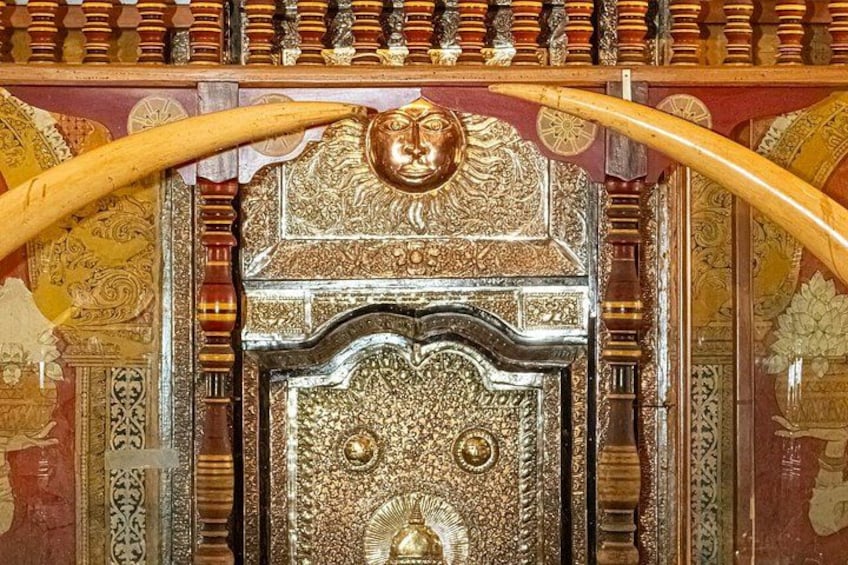 An ornate door with intricate carvings and two large wooden handles. 2