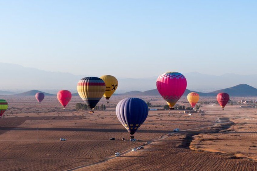 Un paysage avec de nombreuses montgolfières aux couleurs vives et un ciel dégagé. 1