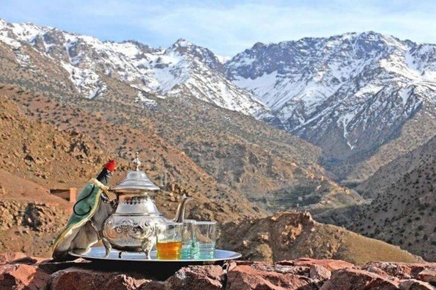 Un service à thé traditionnel est disposé sur une table, avec un paysage montagneux en arrière-plan. 3