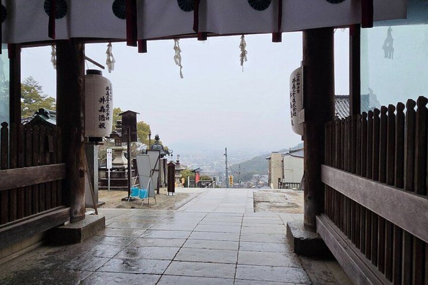 A traditional Japanese gate with wooden railings and a tiled pathway leading through it. 2