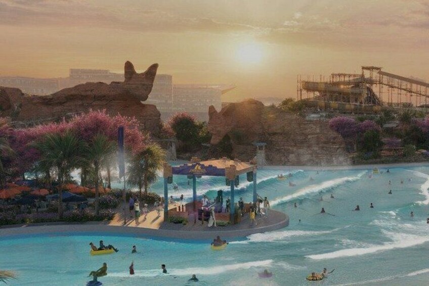 A water park with a large pool, palm trees, and a rock formation. 1