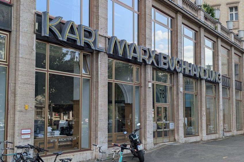 Ein Gebäude mit dem Schild 'KARL MARX BUCHHANDLUNG' und der Zahl '78' im Fenster. 3