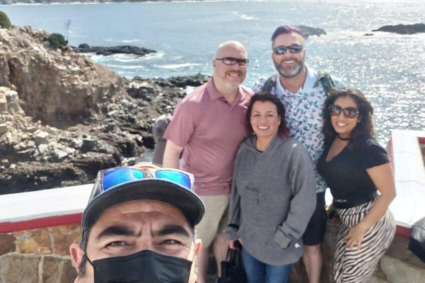 Un groupe de personnes se tient sur une côte rocheuse, avec l’océan en arrière-plan. 2