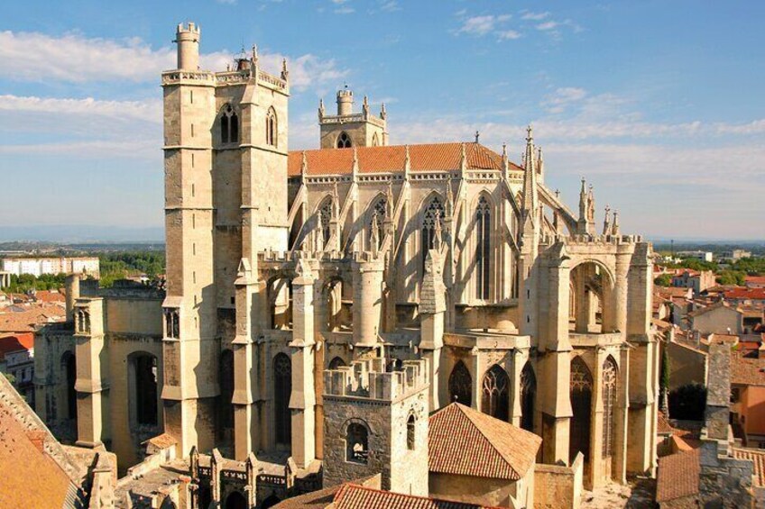 A historic cathedral with Gothic architecture, including flying buttresses and a prominent tower. 1