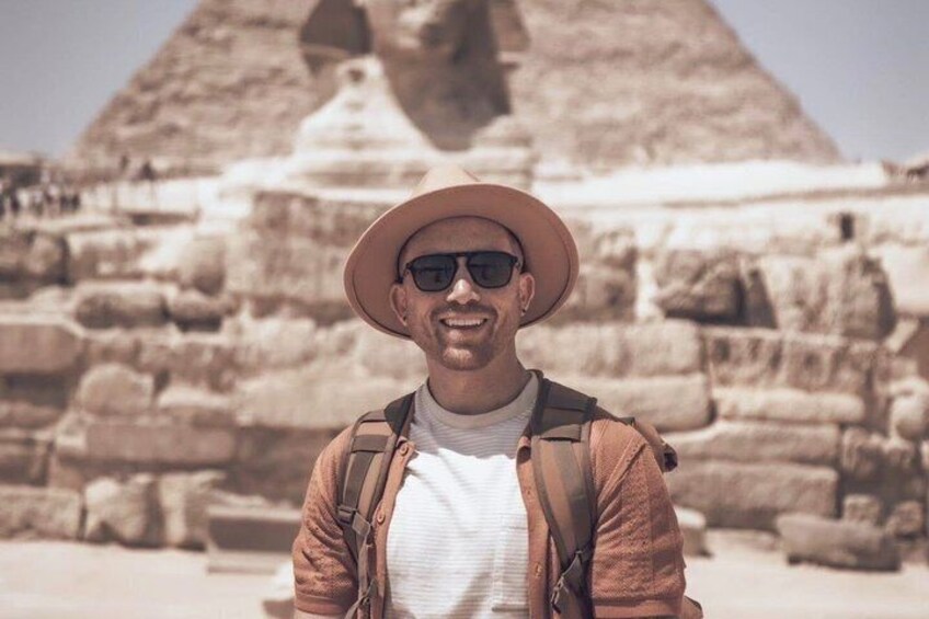 Una persona de pie frente a la Gran Pirámide de Giza. 4