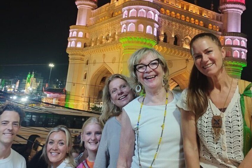 A group of people in front of a brightly lit building with arches and domes. 2