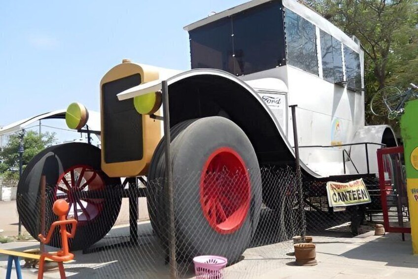 A vintage truck with large red wheels and a yellow front grille. 5