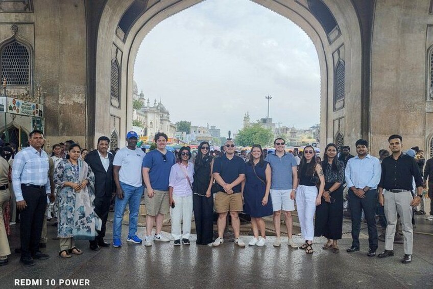 A group of people standing in an archway with a cityscape in the background. 3
