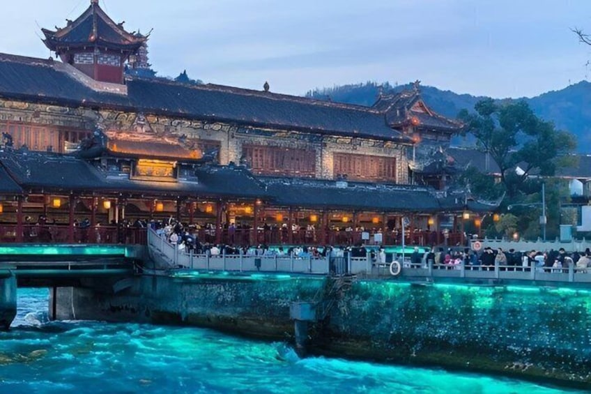 A traditional Chinese building with a tiled roof and a bridge over a river. 3