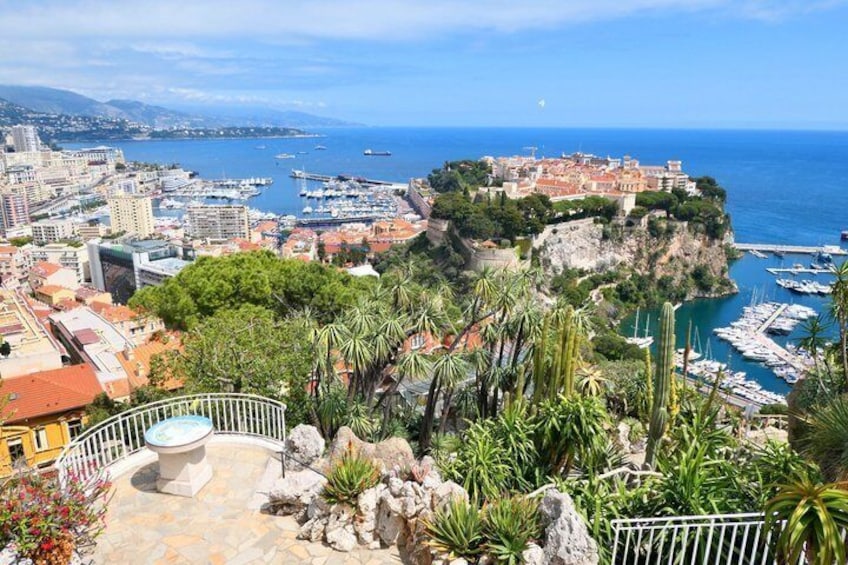 A coastal cityscape with a prominent cliff, marina, and lush greenery. 5
