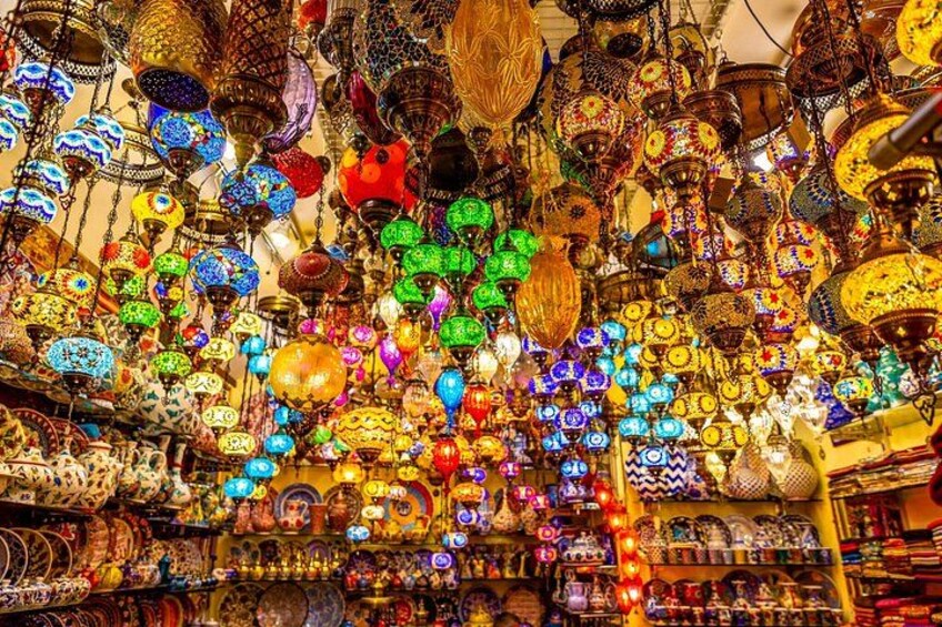 A market with colorful hanging lanterns and various items on display. 4
