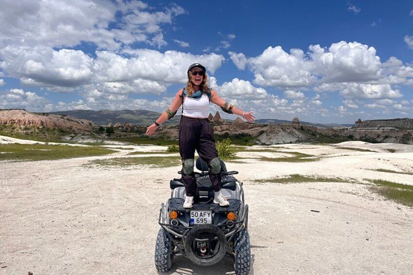 Una persona en un cuatrimoto en un paisaje árido con colinas al fondo. 5
