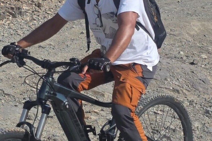 En person som cyklar på en mountainbike på en stenig stig. 4