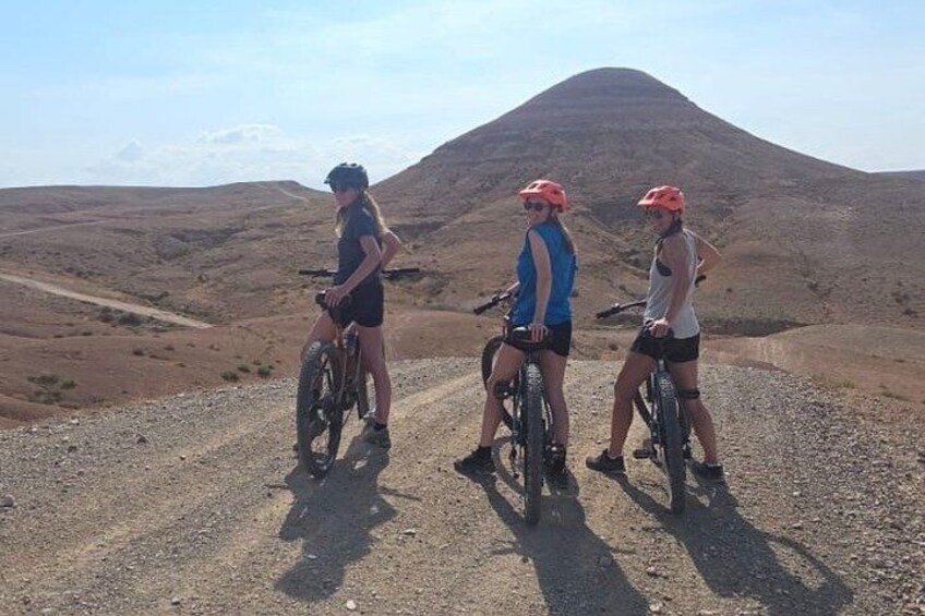 Tre cyklister på en grusväg med ett berg i bakgrunden. 3