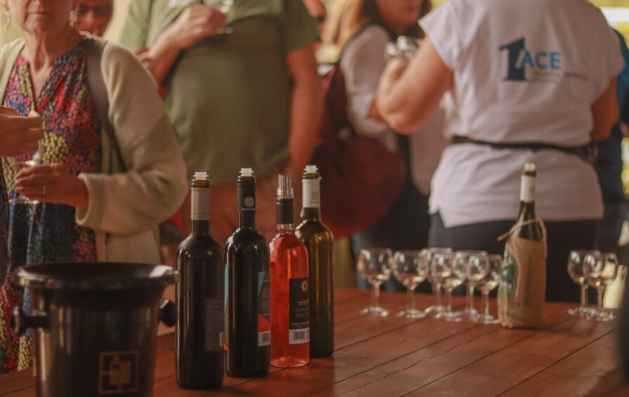 A wooden table with wine bottles and glasses. 1