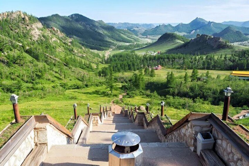 Eine Treppe führt zu einem Aussichtspunkt mit Blick auf ein Tal und Berge in der Ferne. 1