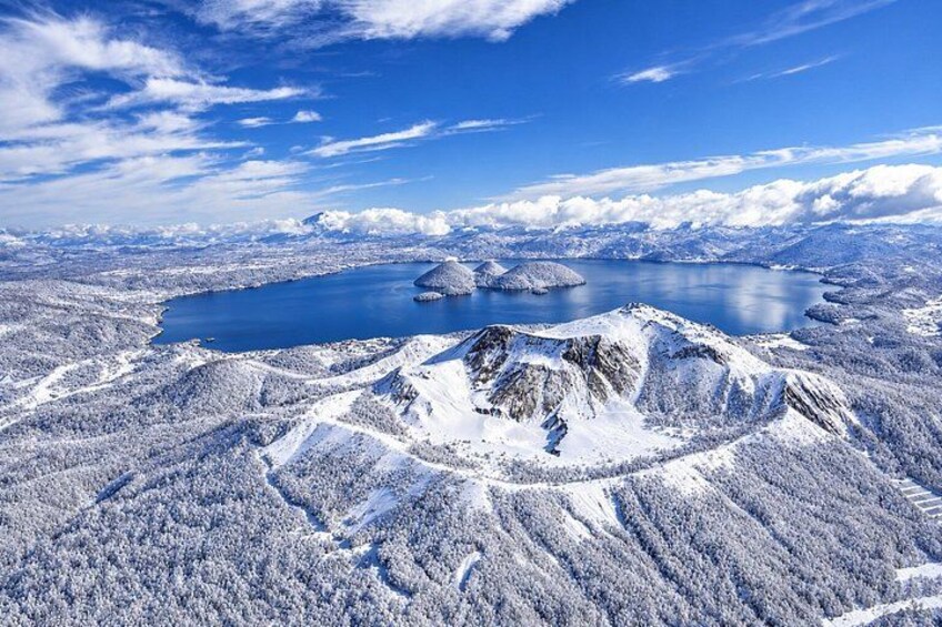 A snow-covered mountain range with a lake and clear blue sky. 2