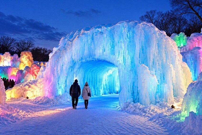 An illuminated ice archway in a snowy landscape. 5