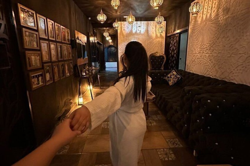 A dimly lit hallway with patterned walls, a sofa, and hanging lanterns. 5