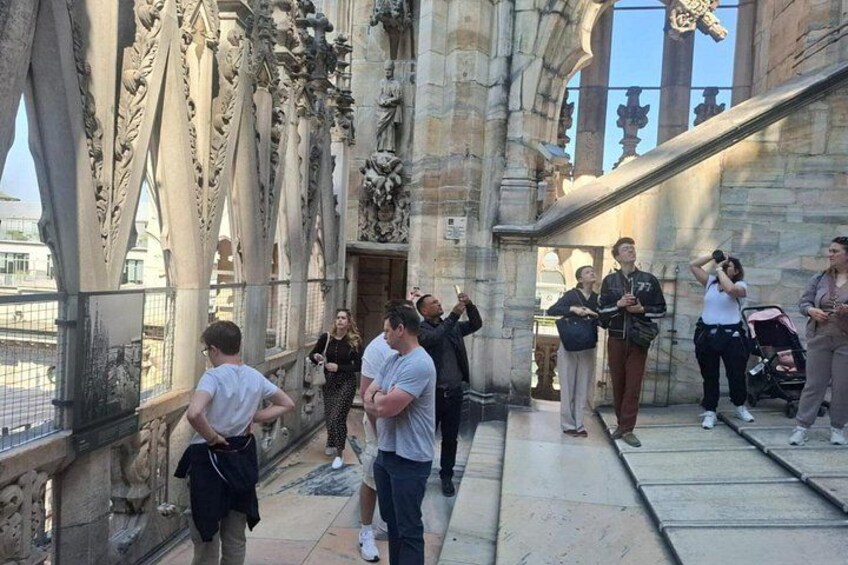 A group of people standing on a stone staircase in a historic building with intricate carvings. 2