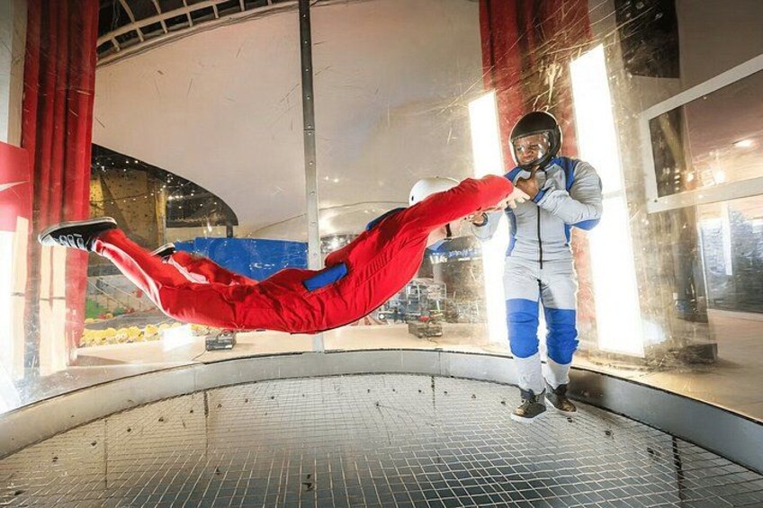 Une personne vêtue d’un costume rouge effectue une cascade sur un trampoline. 5
