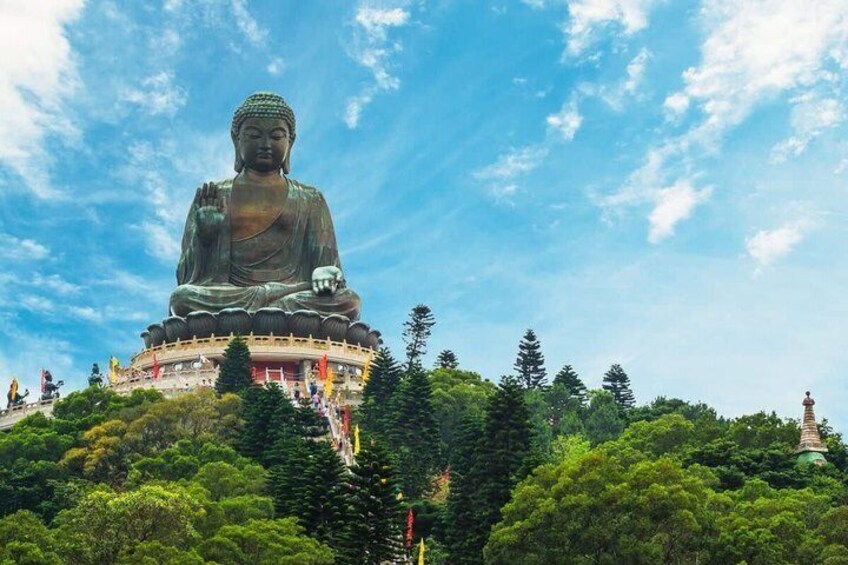 A large Buddha statue on a hill with a clear sky. 1
