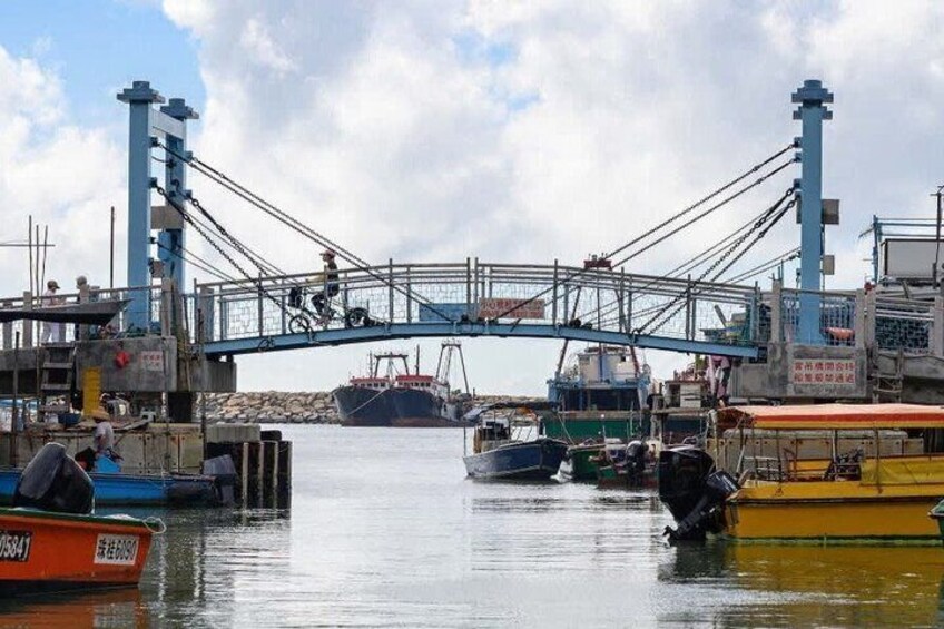 A harbor with a bridge, boats, and industrial structures. 4