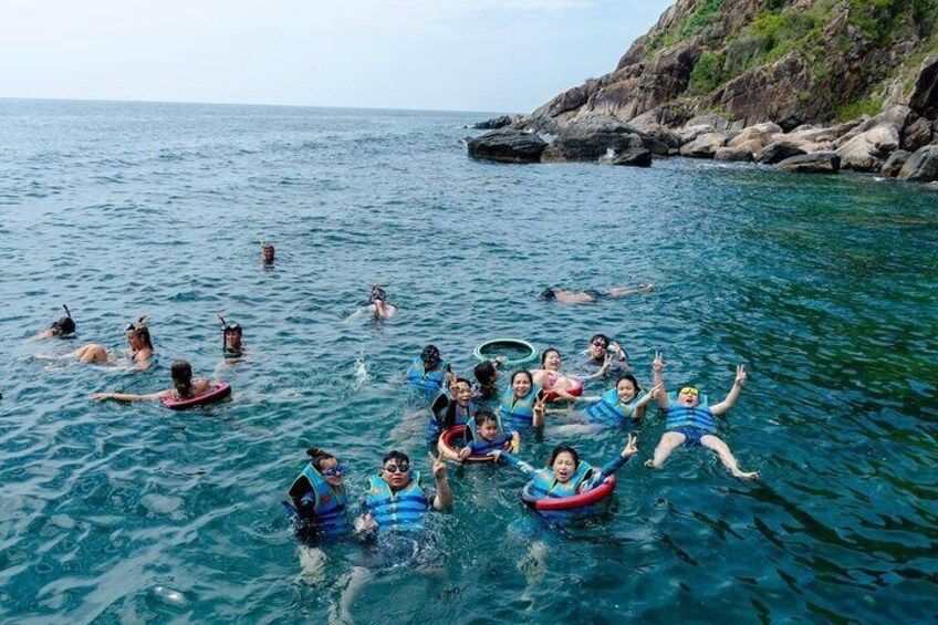 Eine Gruppe von Menschen treibt im Wasser mit aufblasbaren Ringen. 2