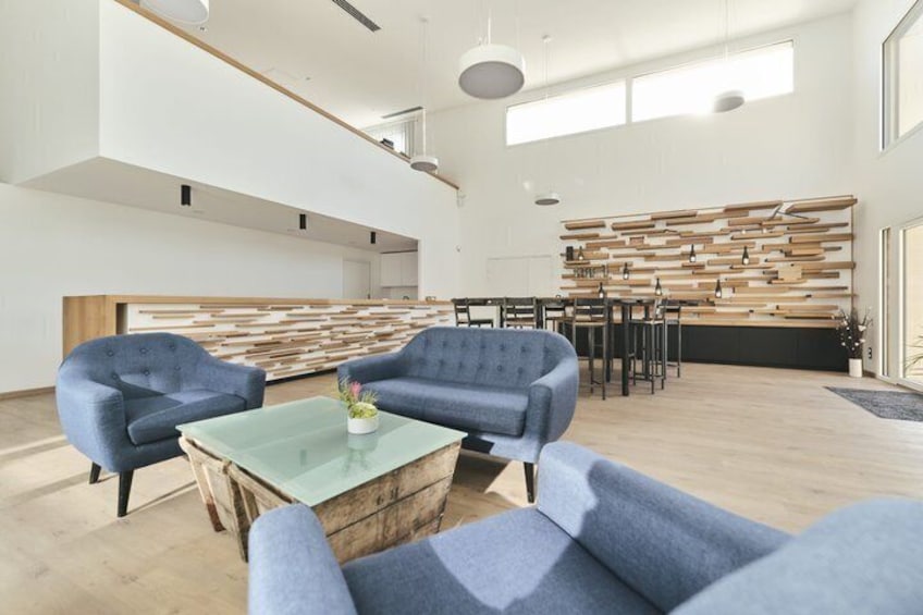 A modern interior with blue sofas, a glass coffee table, and a wooden wall panel. 1