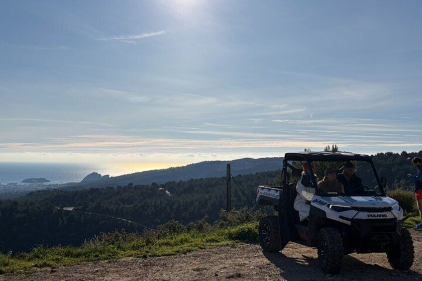 A Polaris ATV on a dirt path with a coastal landscape in the background. 5